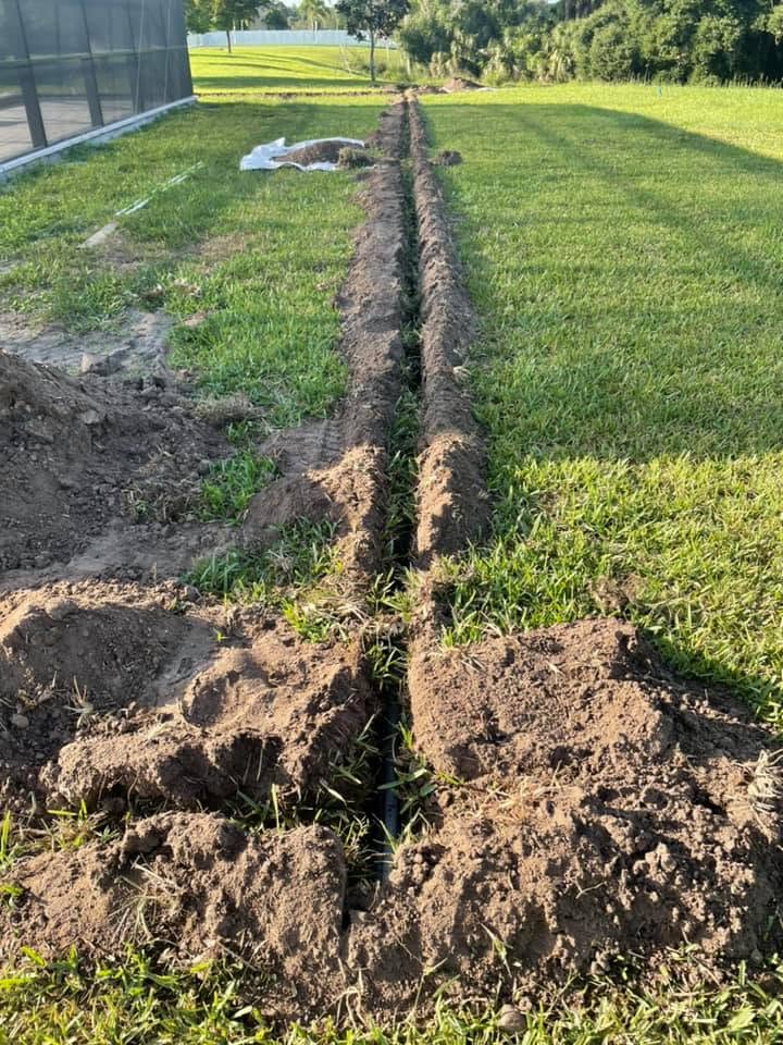 An open irrigation trench beside a screened lanai